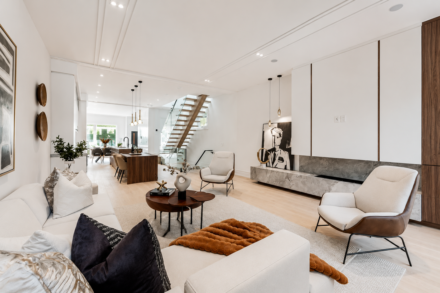 Open-concept living room with white seating, wood accents, and floating staircase