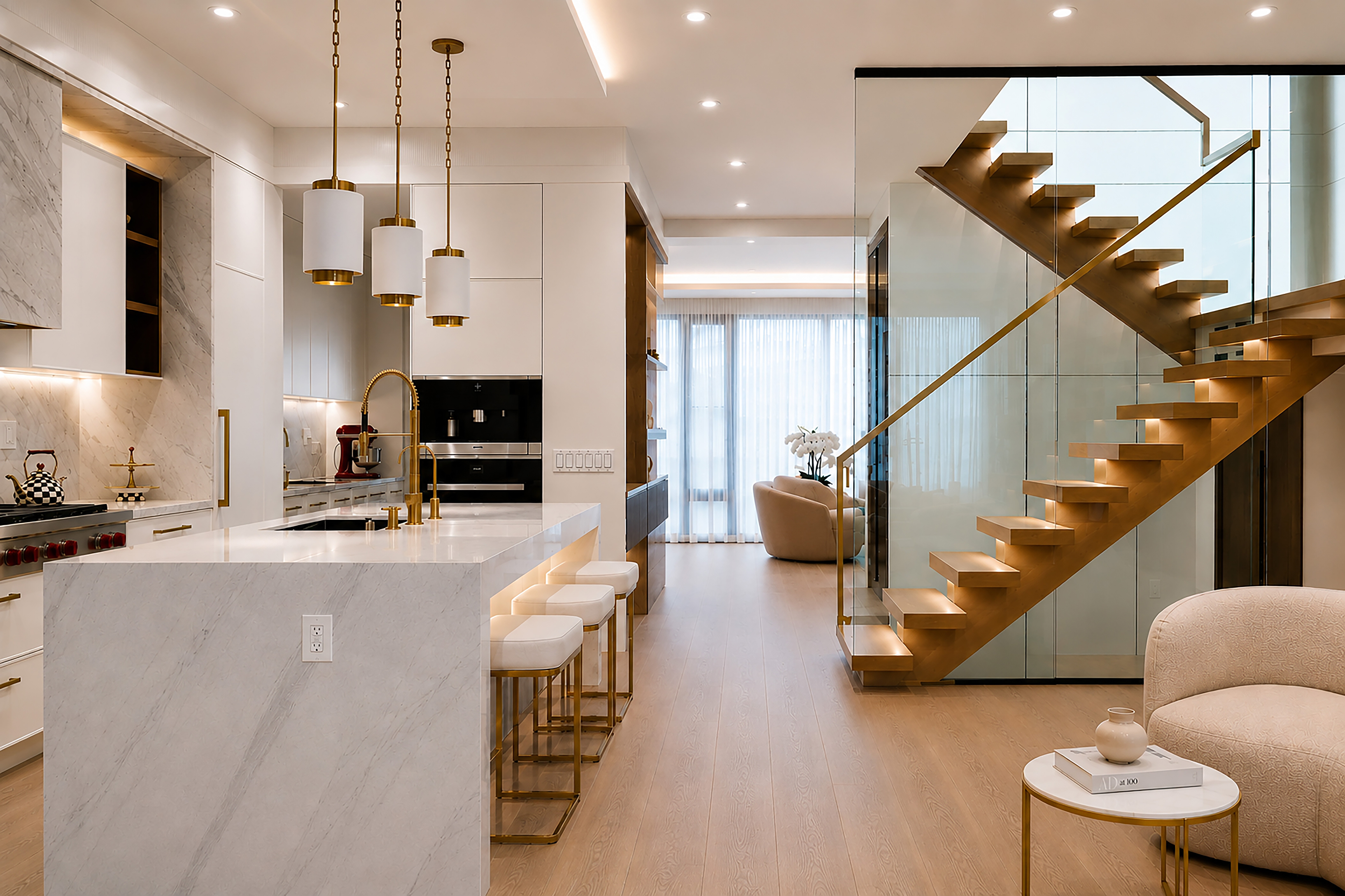 Open-plan kitchen and living space with marble island and floating wood staircase