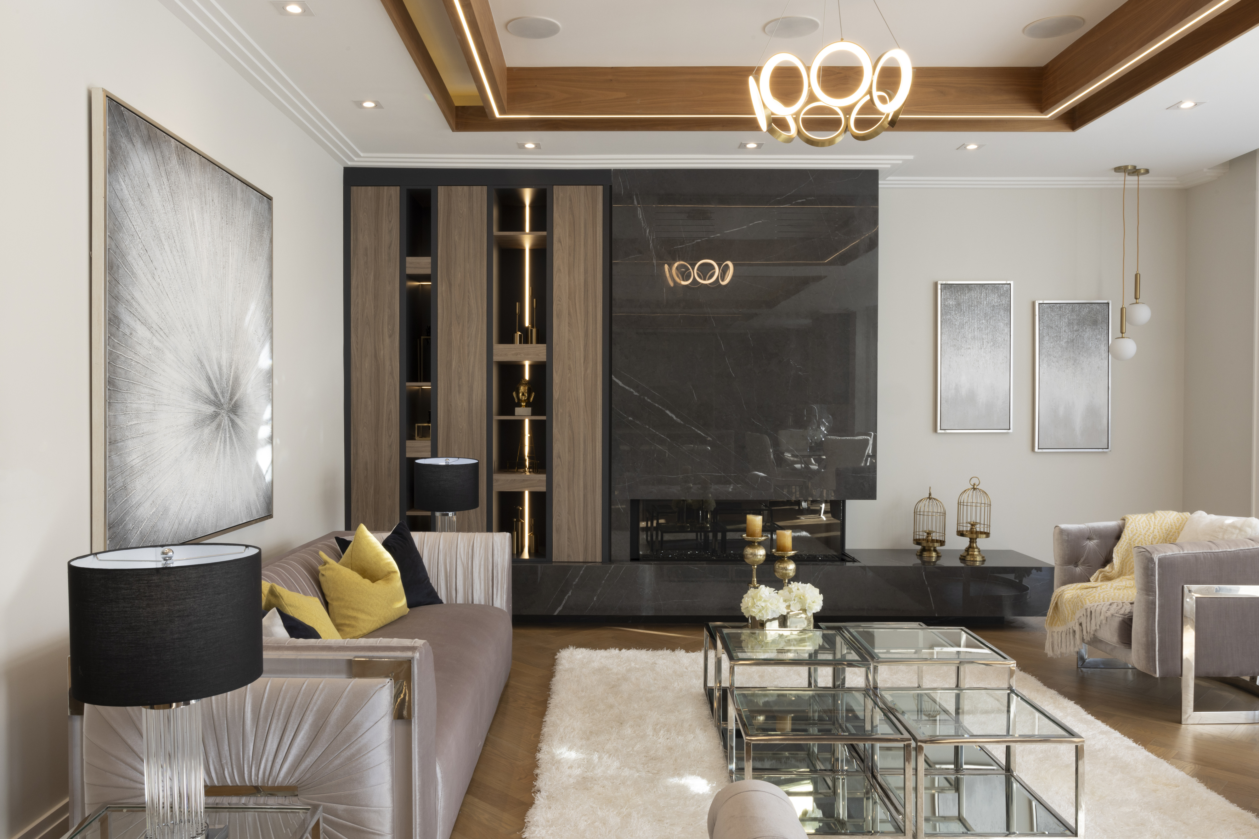 Contemporary living room with dark stone feature wall, built-in shelving, and glass coffee table