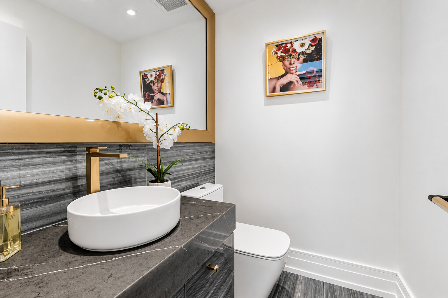 Powder room with vessel sink, dark stone vanity, gold faucet, and framed artwork
