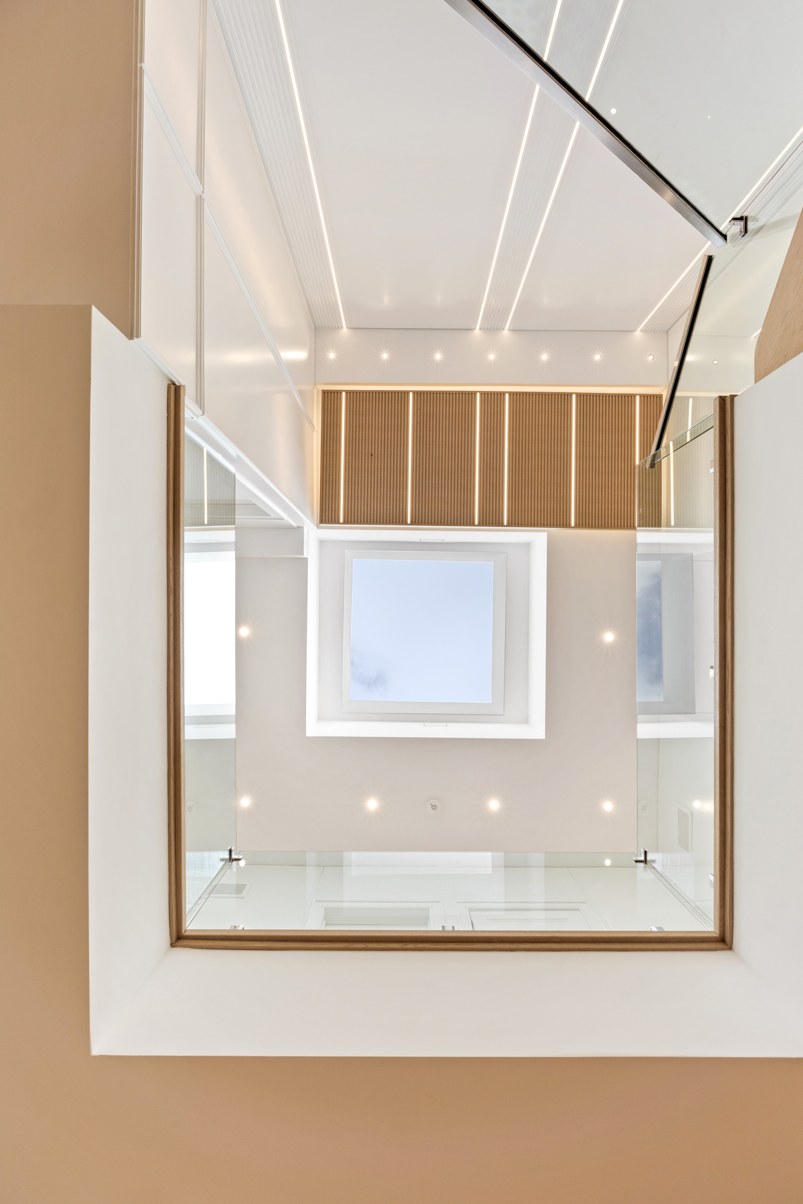 Double-height interior with wood ceiling panels, recessed lighting, and large framed artwork