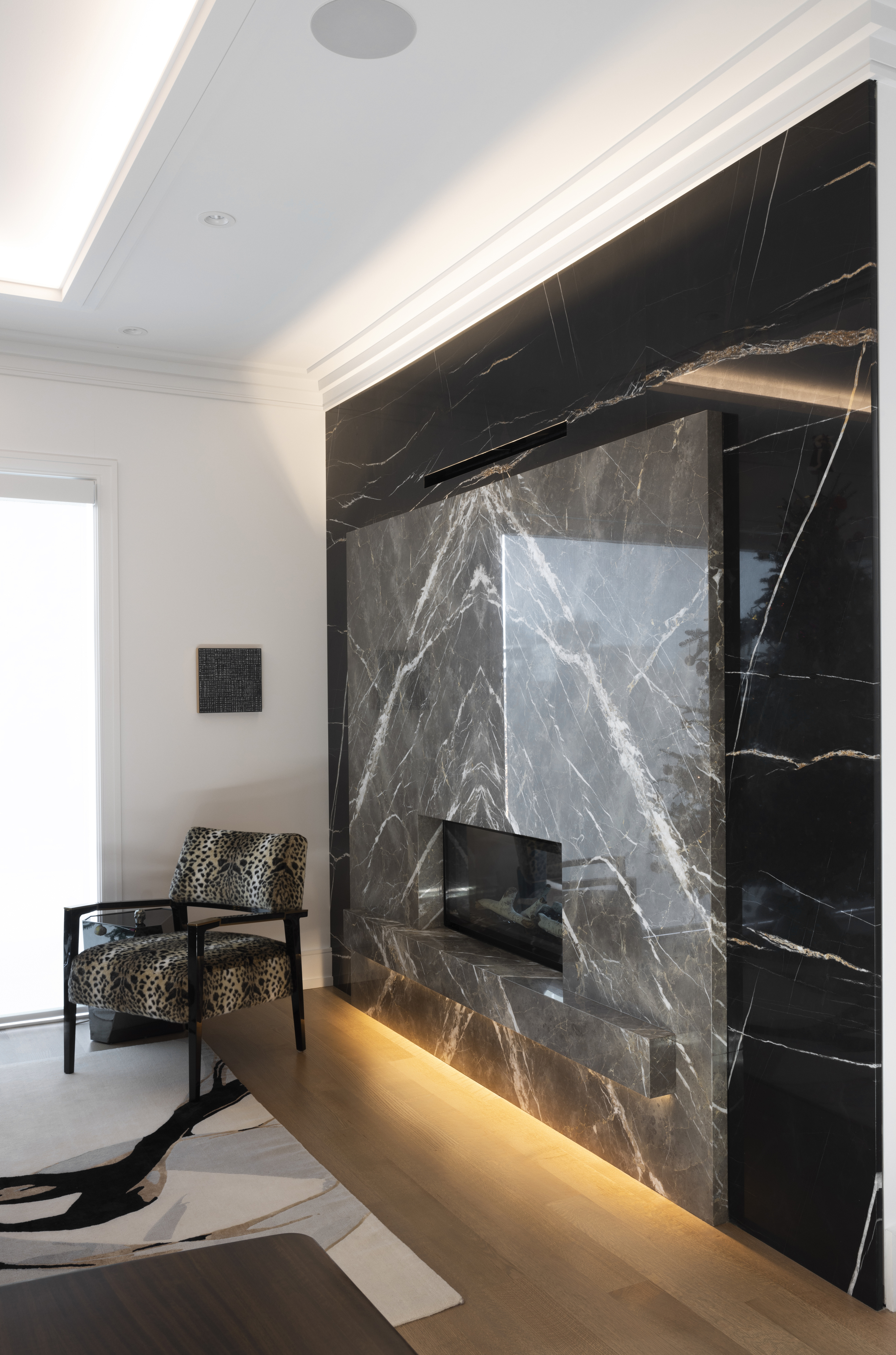 Dramatic black marble fireplace with floor-to-ceiling stone surround