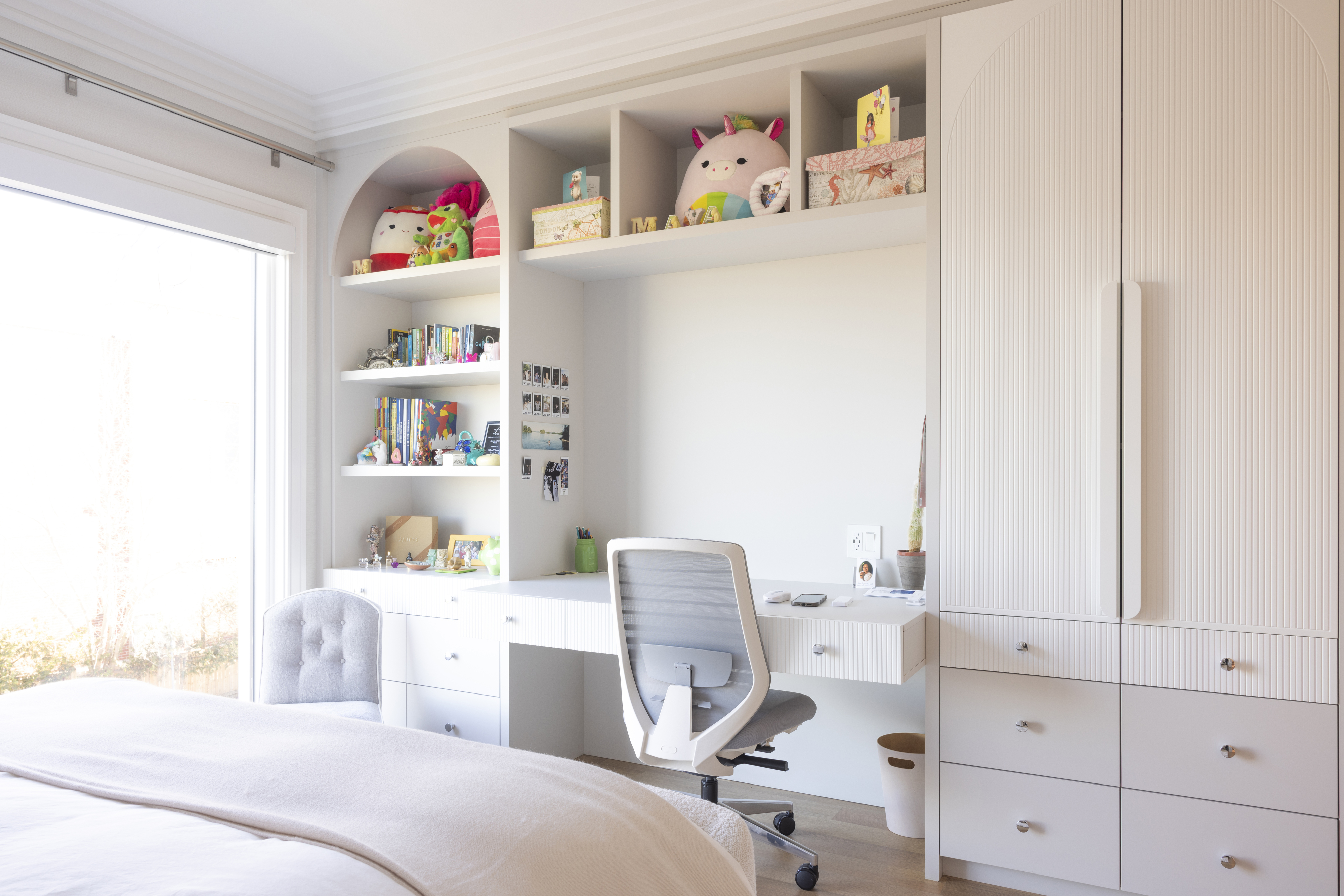 Bedroom with custom built-in desk, shelving, storage, and display space