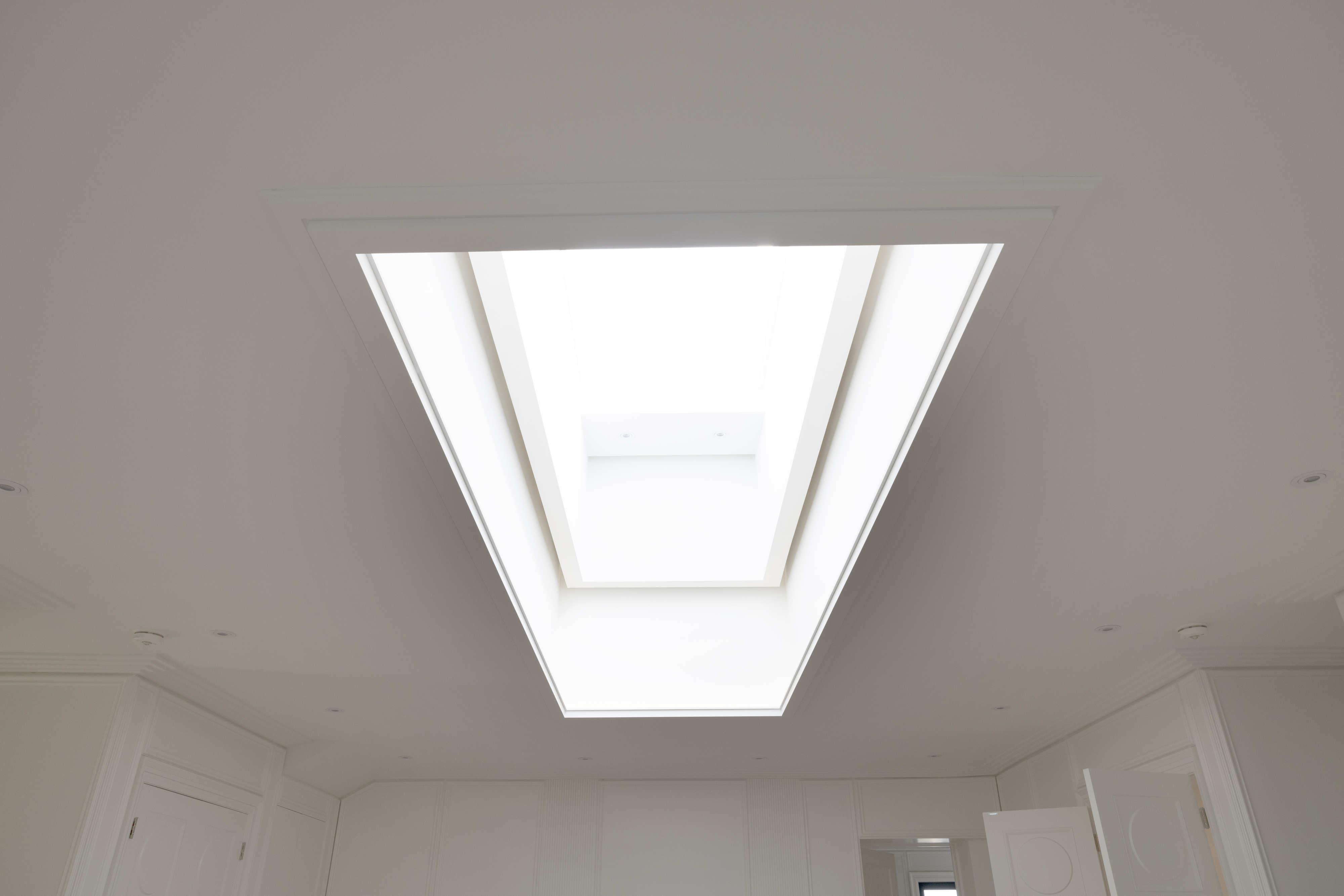 Large rectangular skylight bringing natural light into a white interior