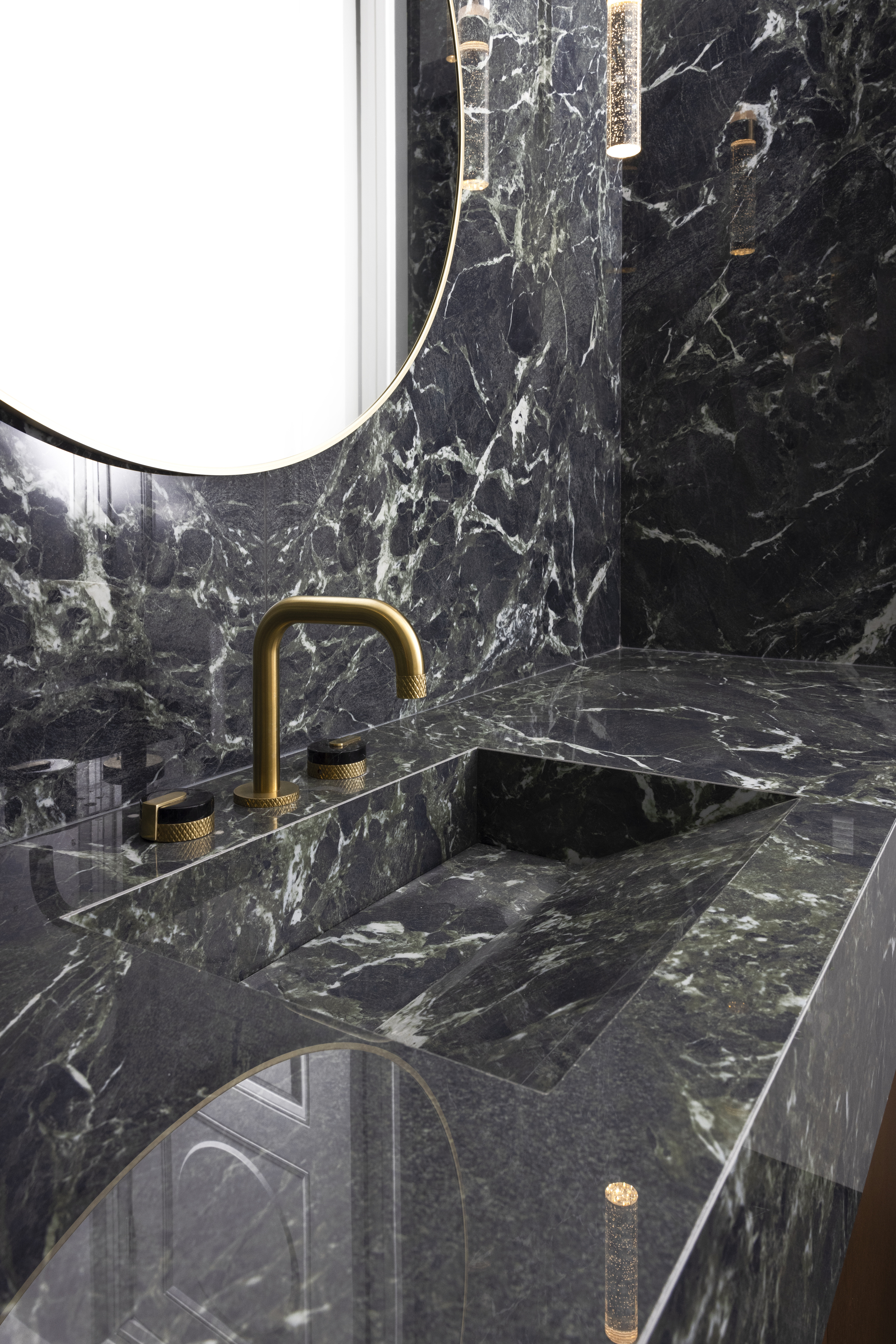 powder room, vanity with black marble sink, matching backsplash, and gold faucet