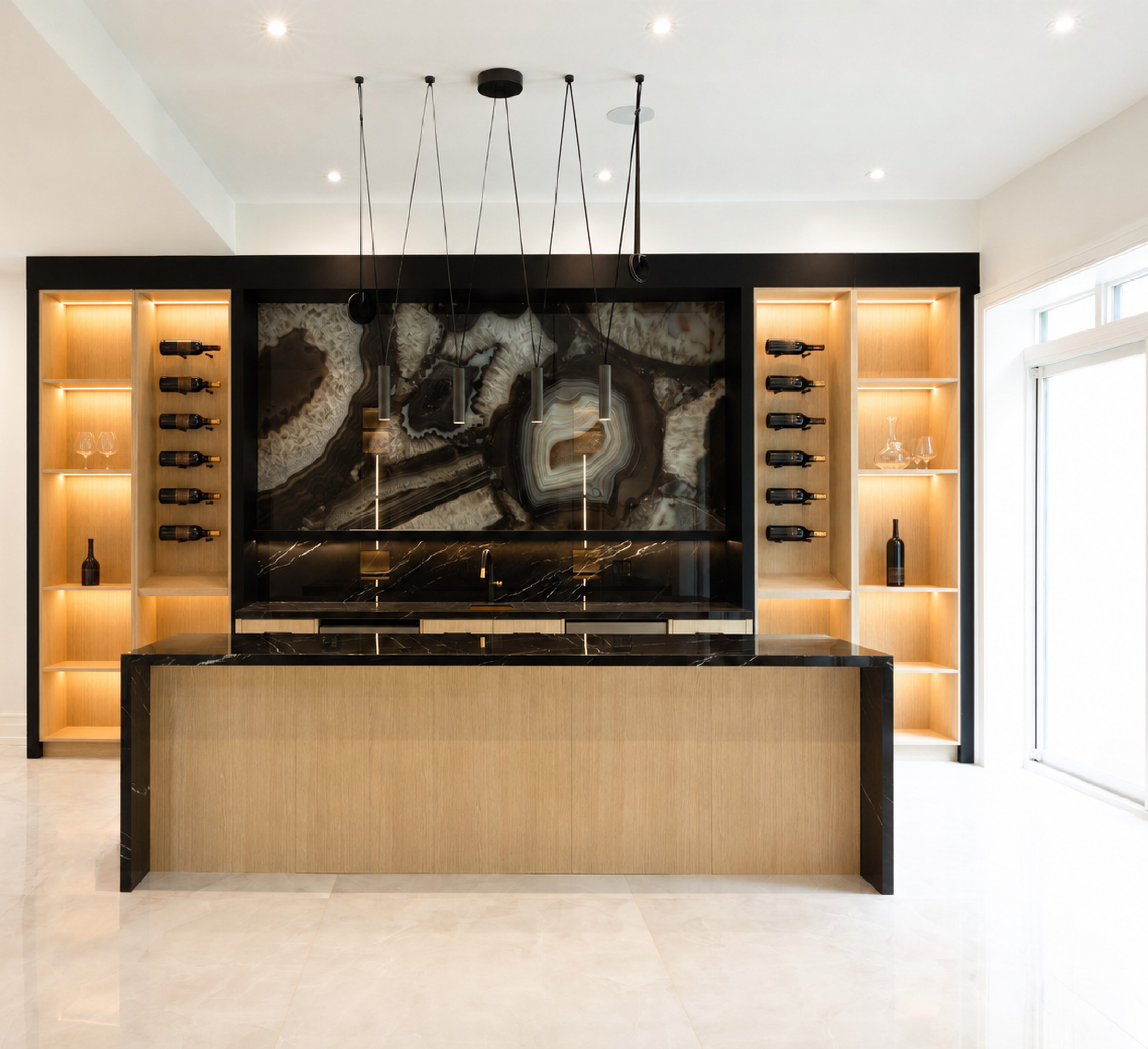 Home bar with dramatic stone backsplash, illuminated bottle shelving, and wood cabinetry