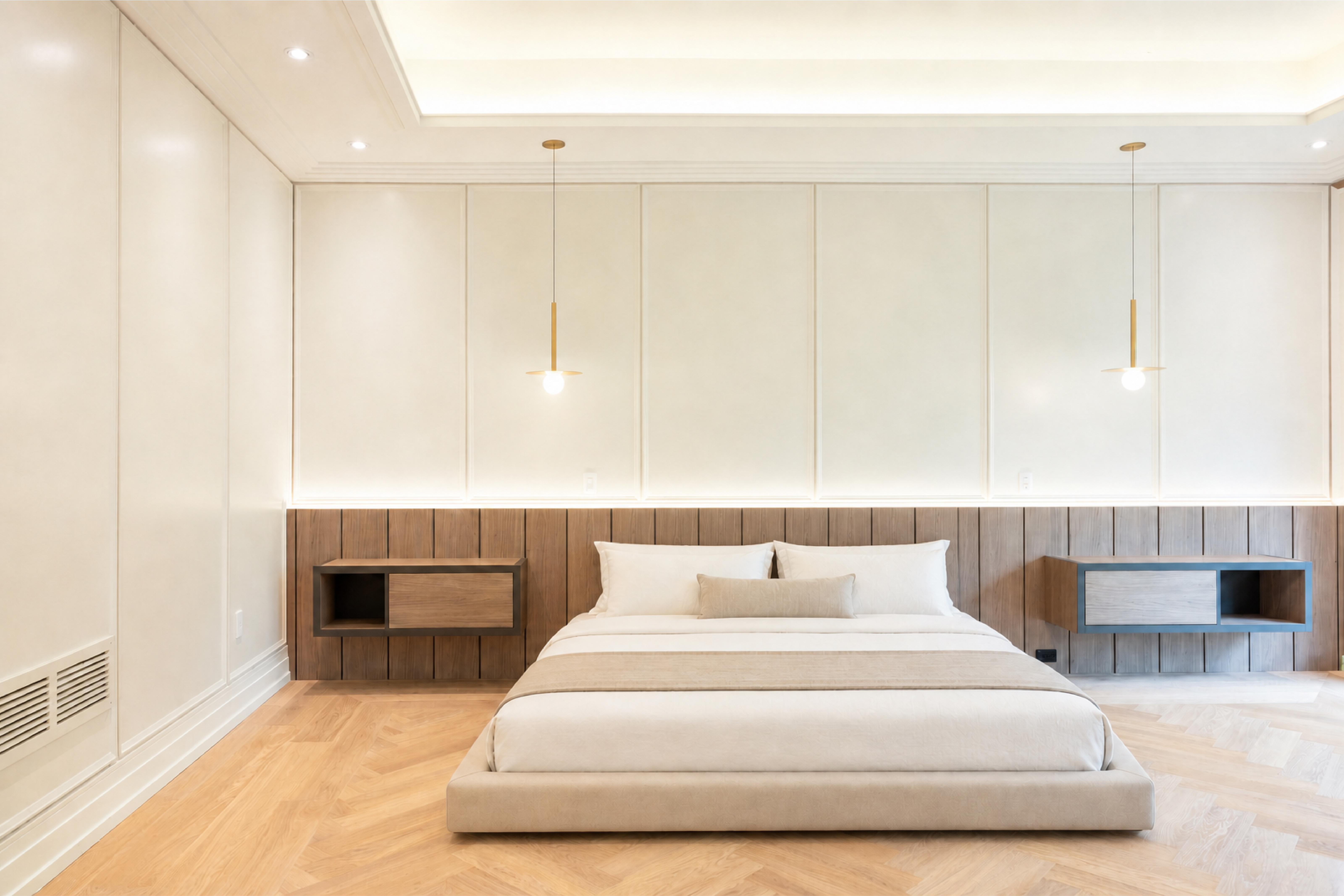 Minimalist bedroom with upholstered platform bed, floating wood nightstands, and pendant lights