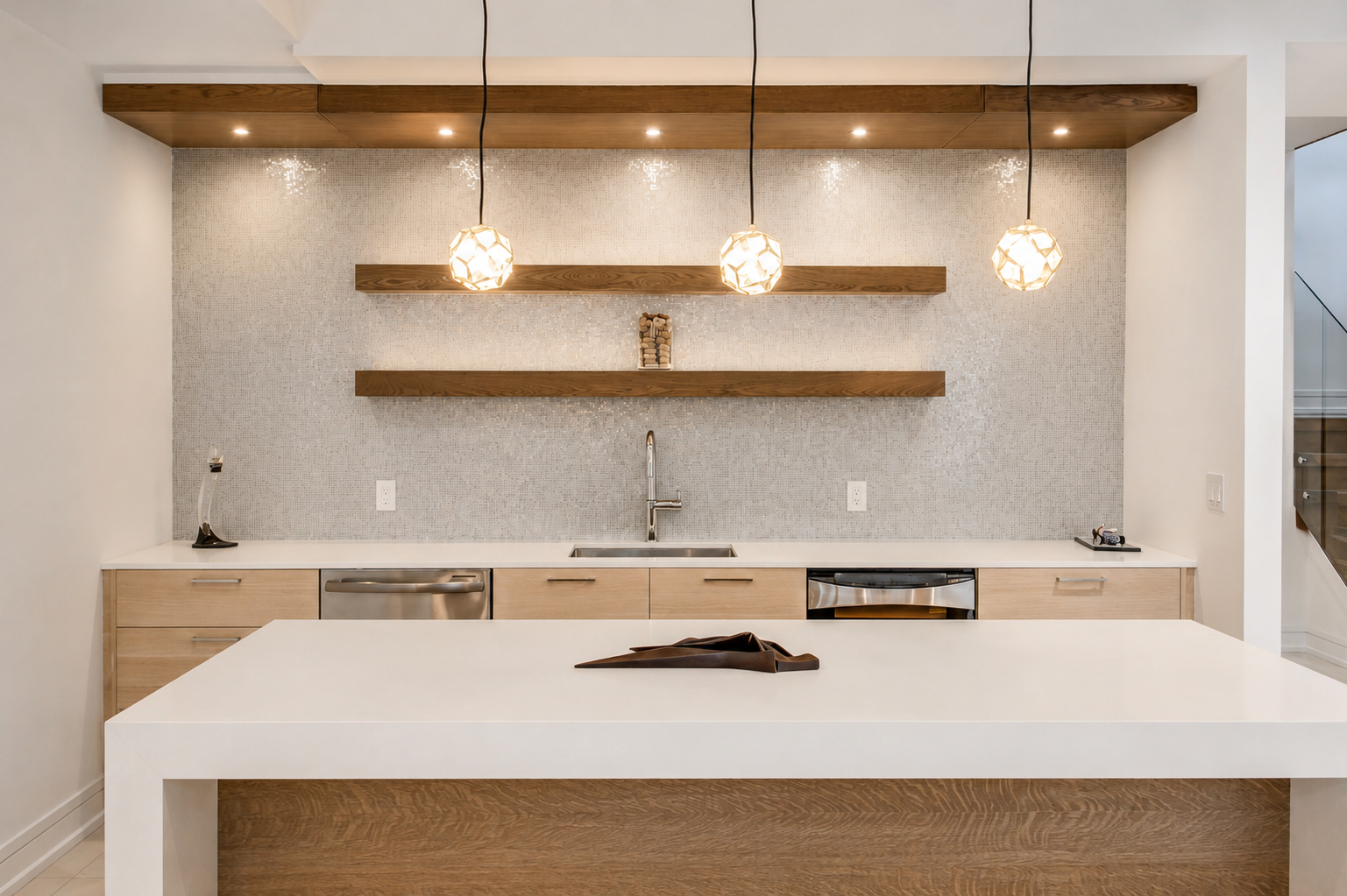 Modern kitchen with white island, light wood cabinetry, floating shelves, and pendant lights