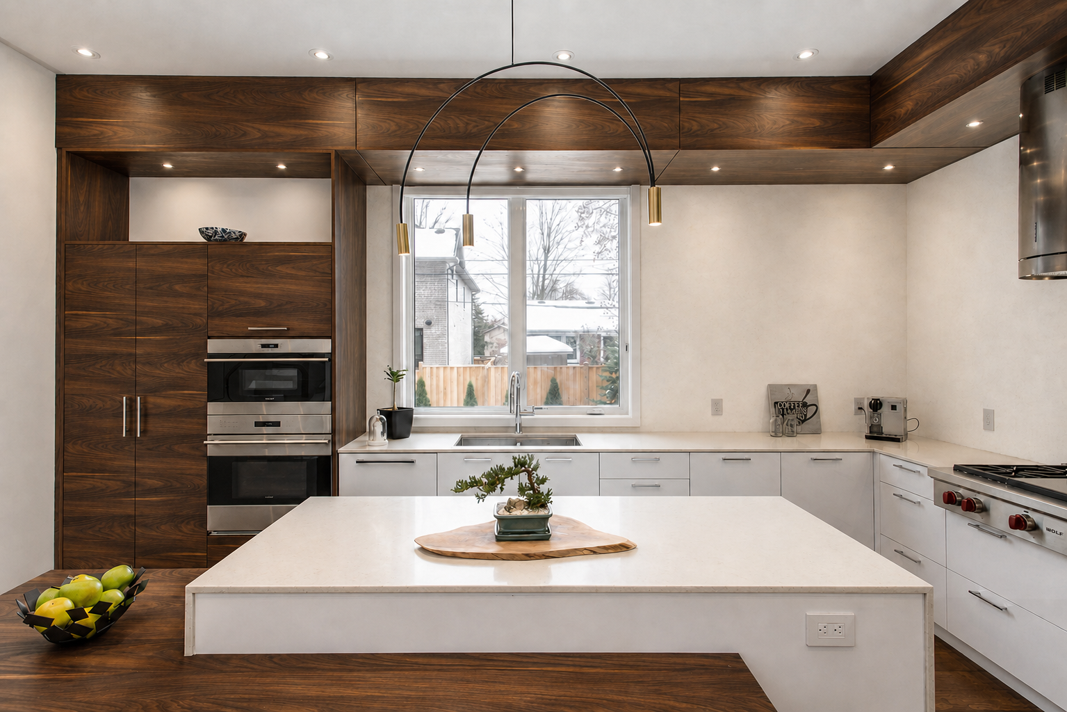 Modern kitchen with large stone island, white cabinetry, dark wood panelling, and circular pendant light