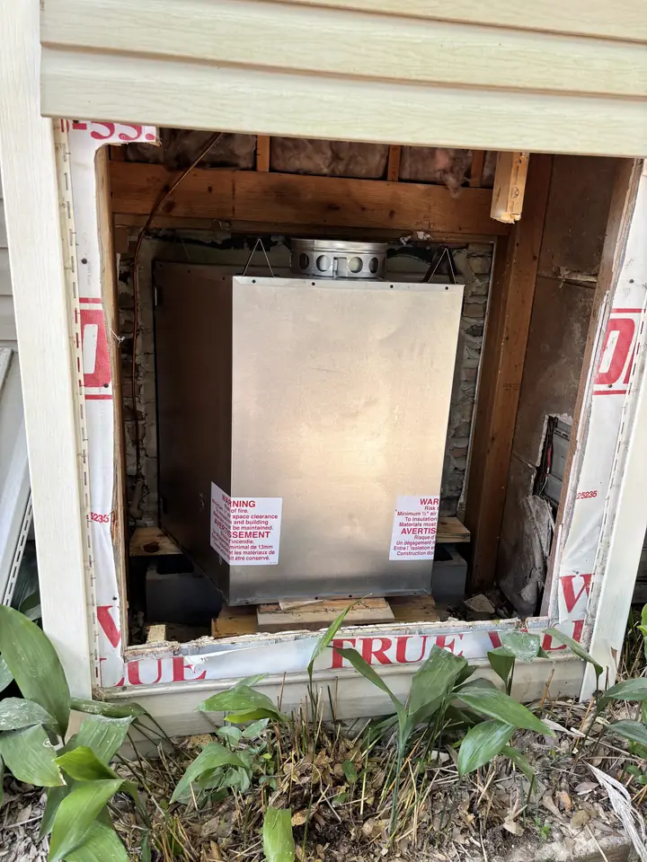 Firebox positioned through the exterior opening during the rebuild.