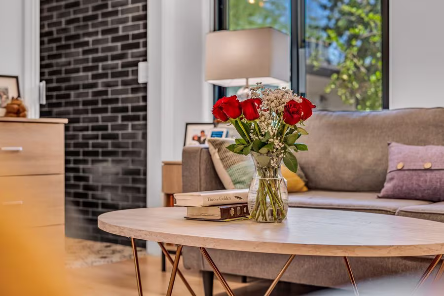 Suite sitting area with a sofa, round coffee table, and window onto the garden