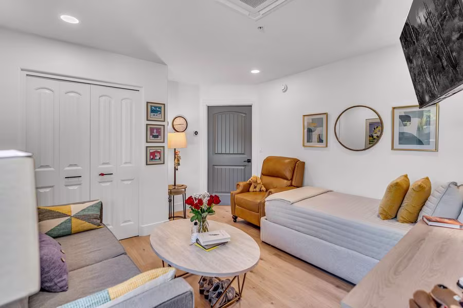 Suite sitting area with a daybed, sofa, framed pictures, and double closet