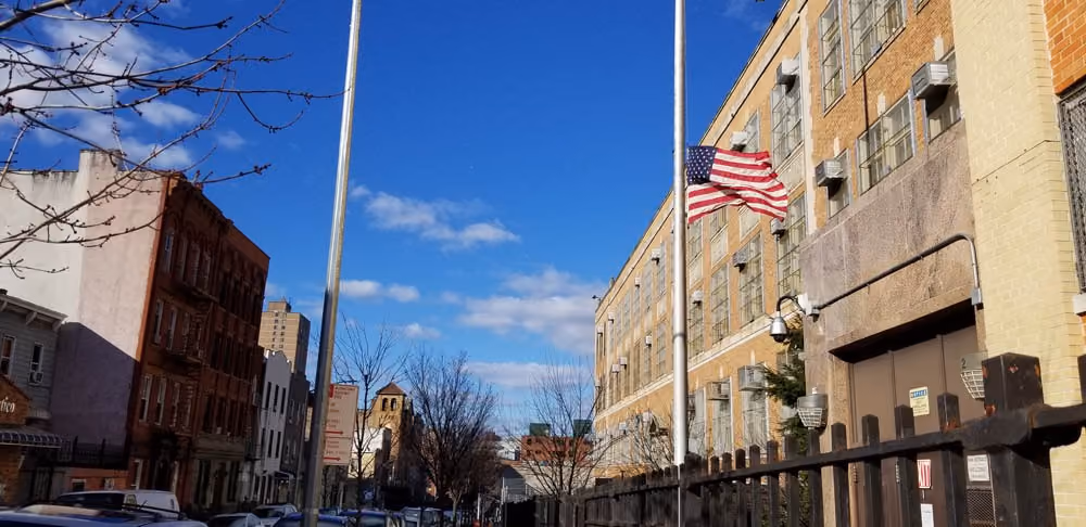 American flag flying at half-staff outside school building
