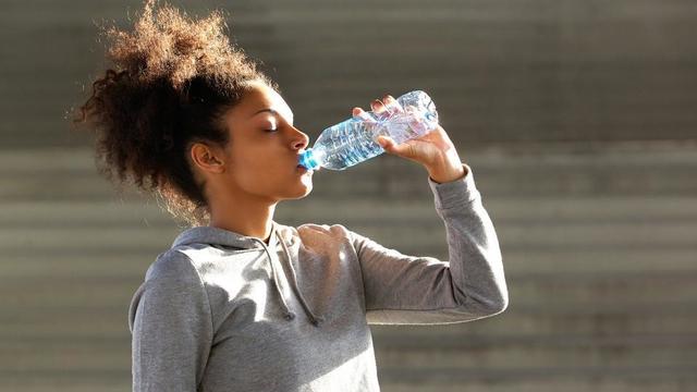 Student drinking water from a bottle after exercise