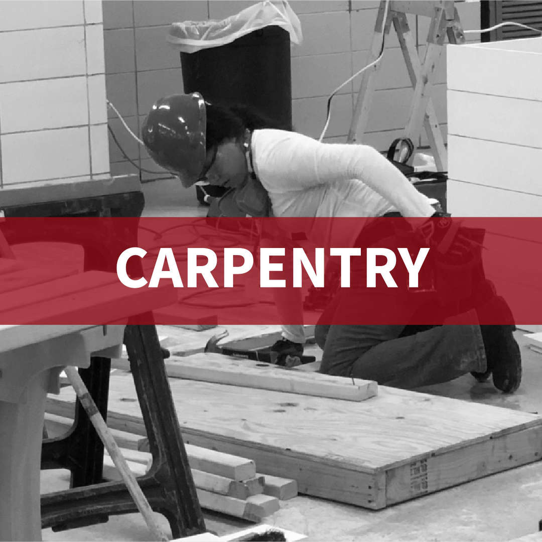 Students wearing hard hats working on carpentry projects in class