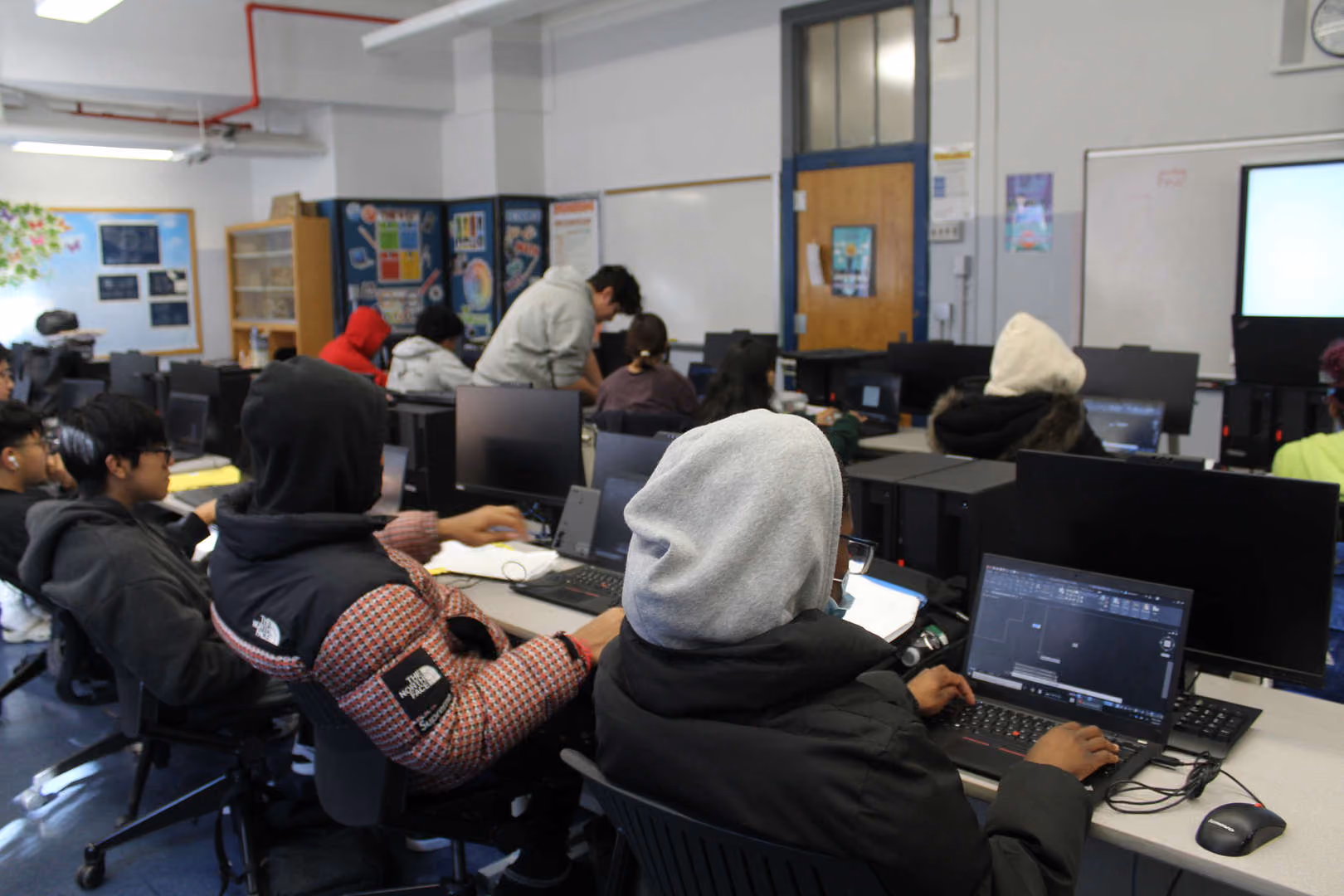 Students working on laptops and computers in a school computer lab