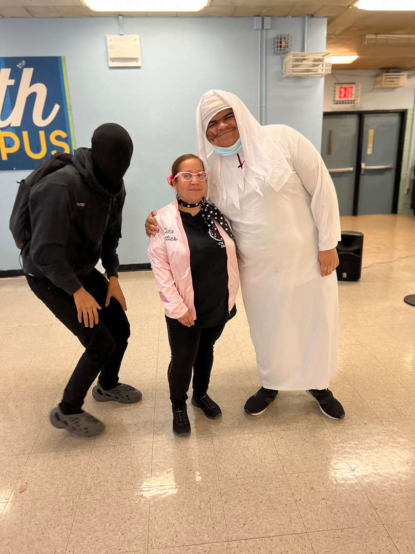 Students and staff posing in Halloween costumes in school hallway