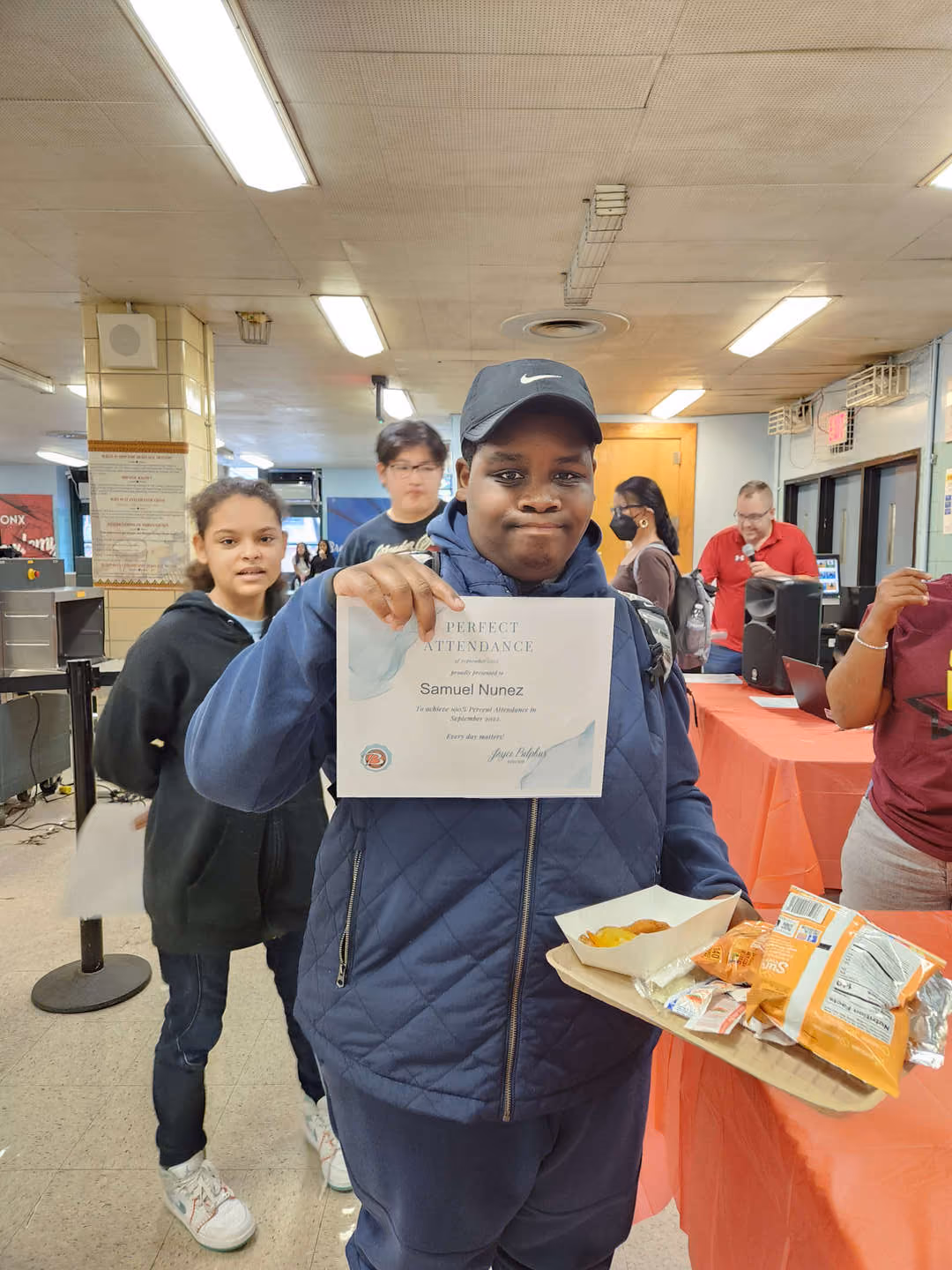 Student Samuel Nunez proudly holds his Perfect Attendance certificate