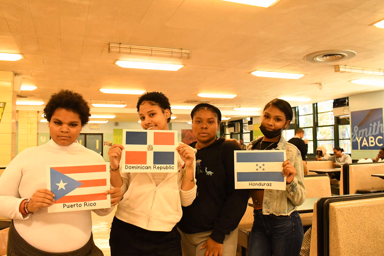 Four students holding Puerto Rico Dominican Republic and Honduras flags