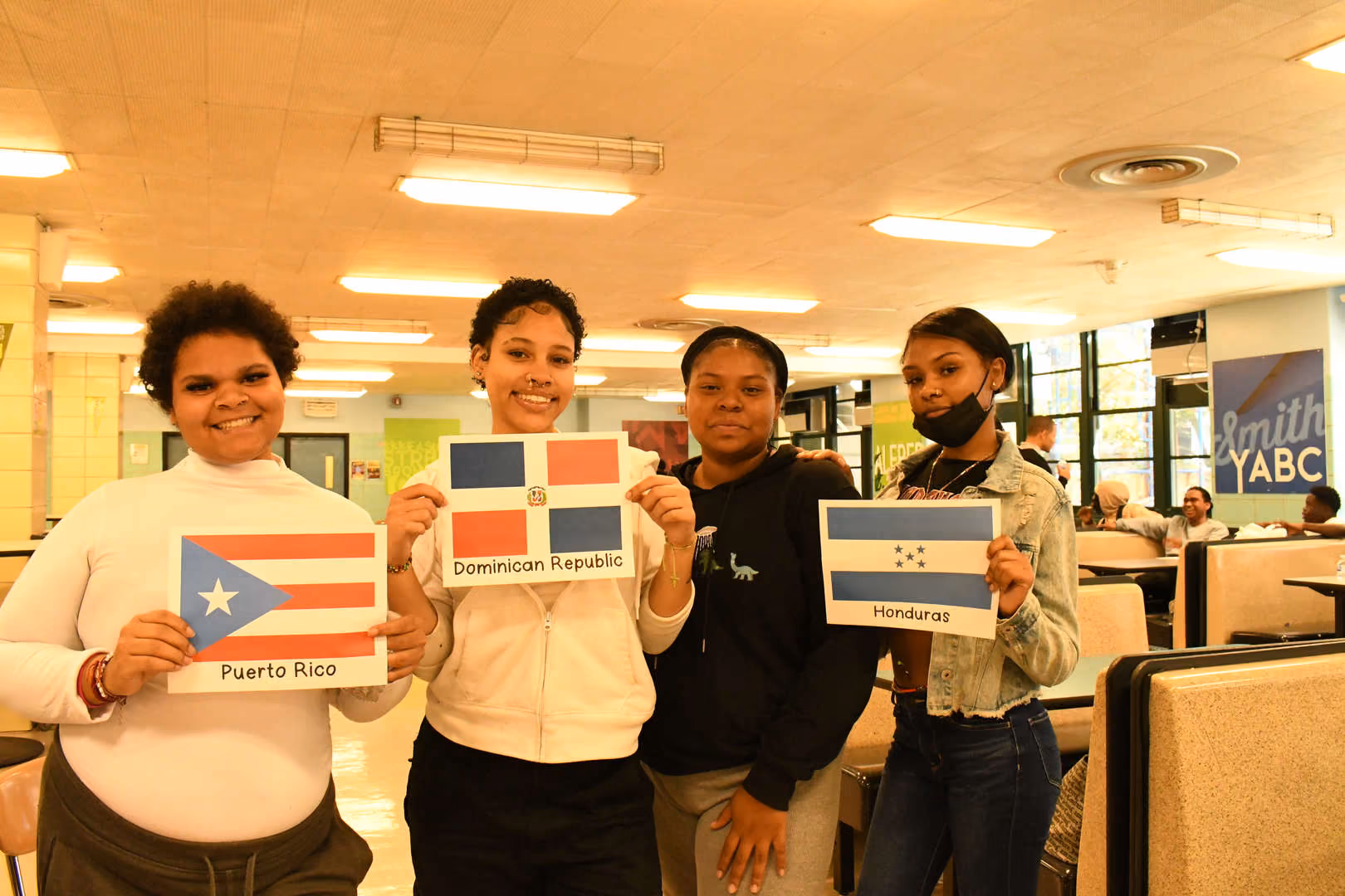Four students holding Puerto Rico Dominican Republic and Honduras flags