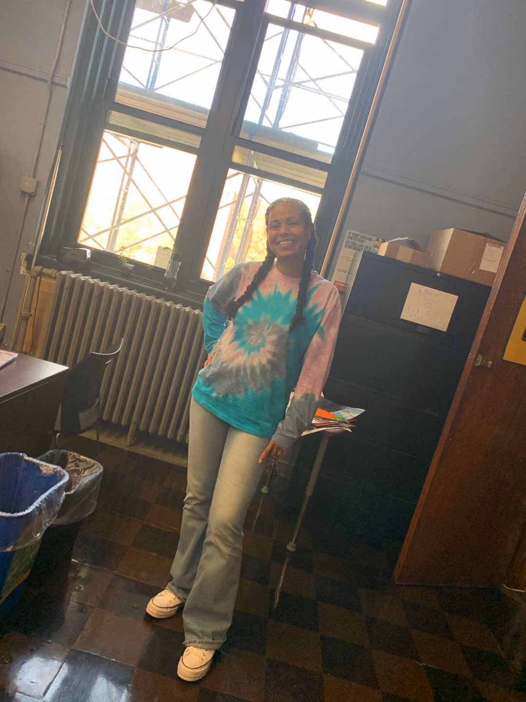 Student smiling in classroom wearing tie-dye shirt on 70s Day
