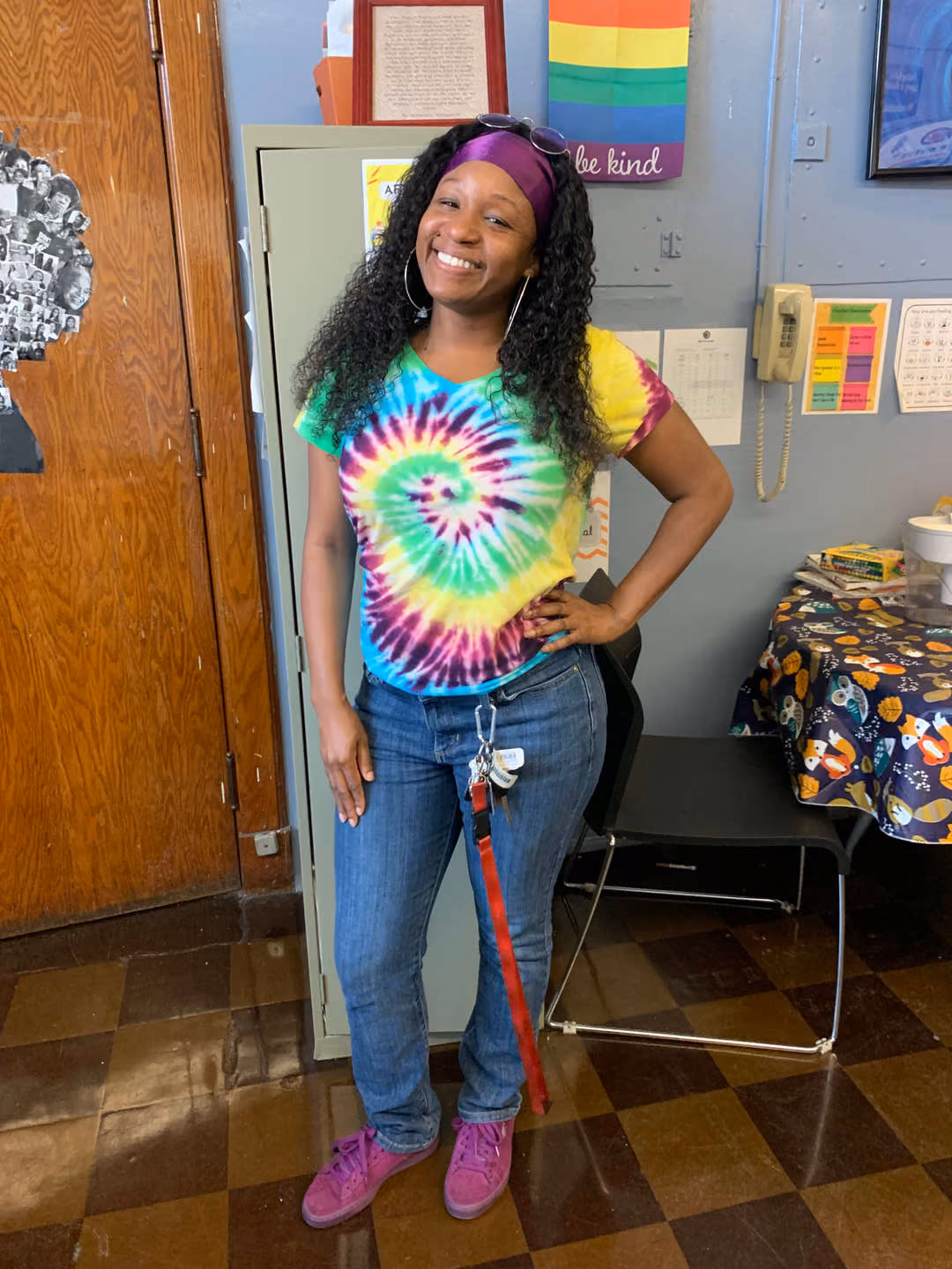 Smiling staff member wearing tie-dye shirt on 70s spirit day