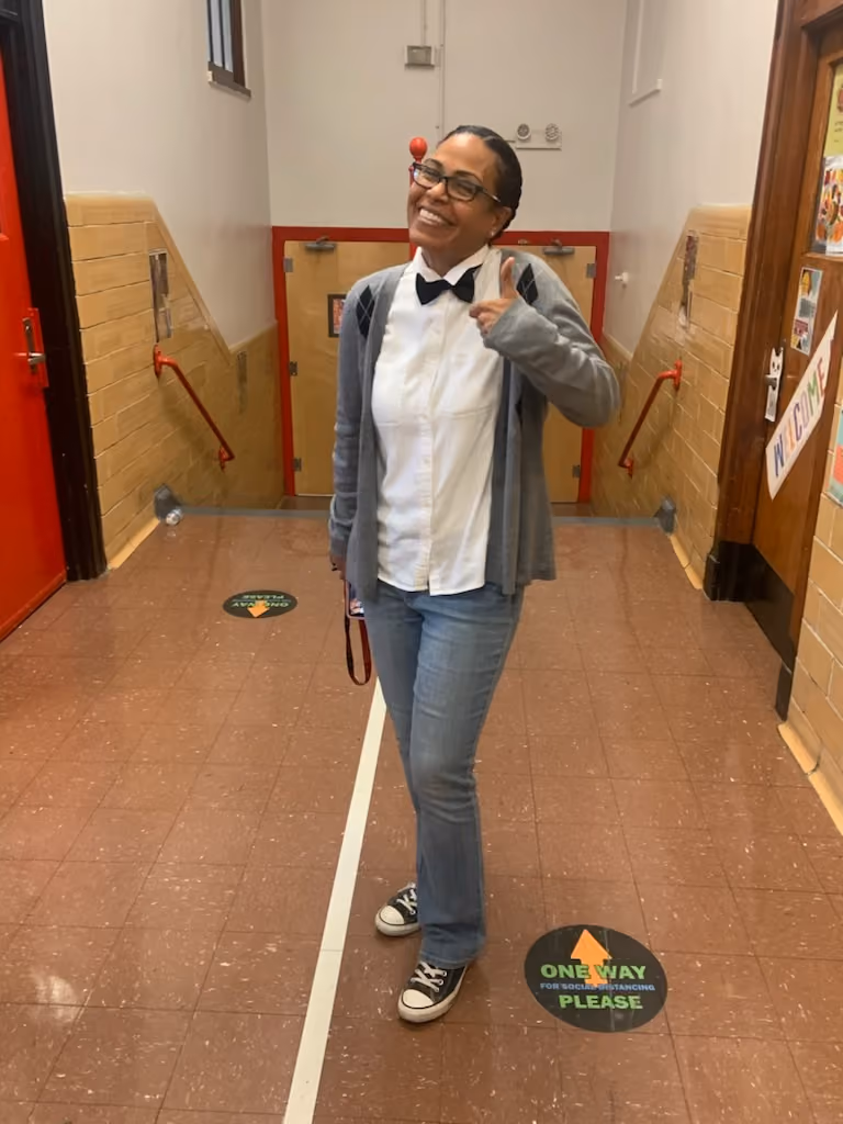 Staff member dressed as a nerd celebrating spirit day in school hallway