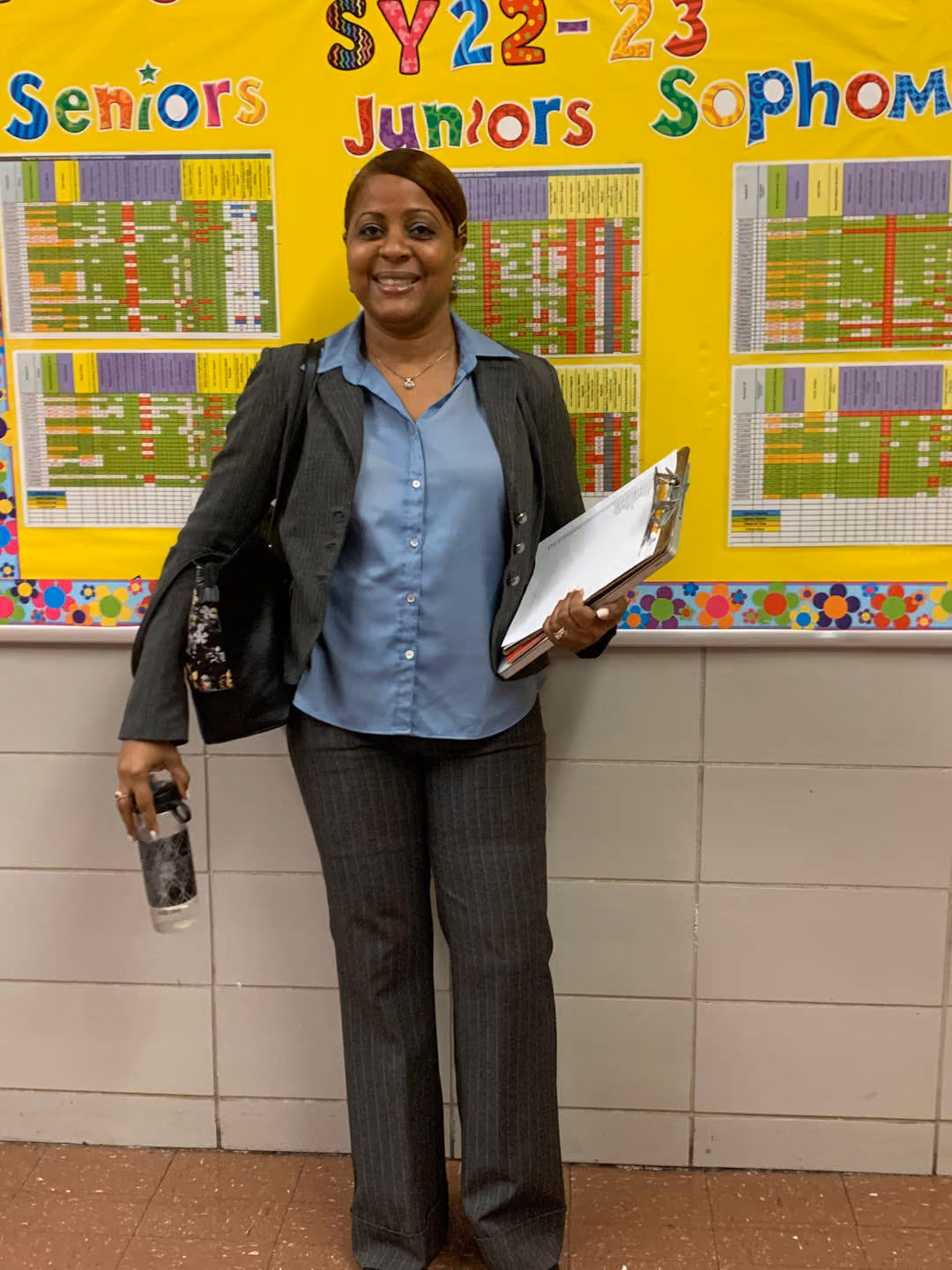 Staff member standing before SY22-23 grade-level tracking bulletin board