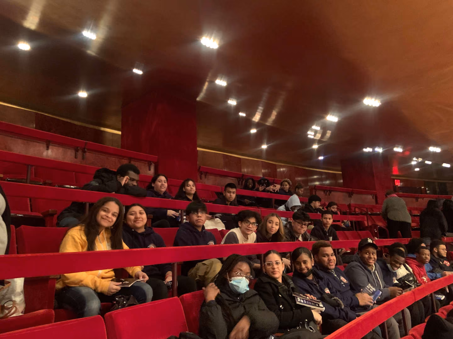 Students seated in red velvet theater seats at the Met Opera