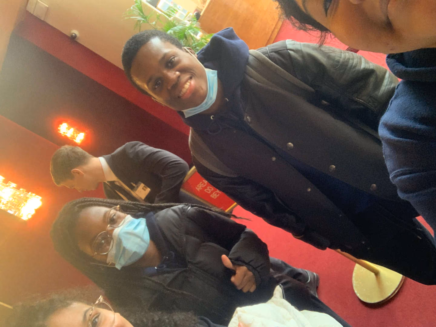 Students wearing face masks posing together at a venue
