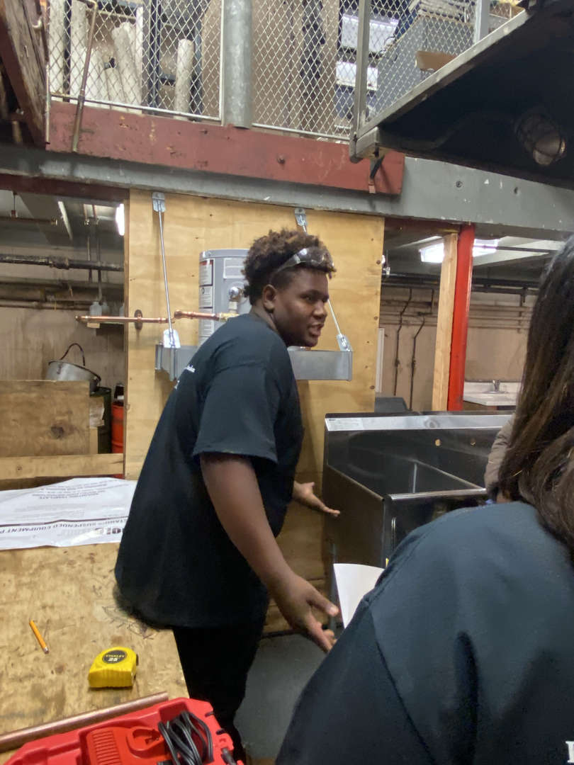 Student working with a metal sink in a vocational workshop