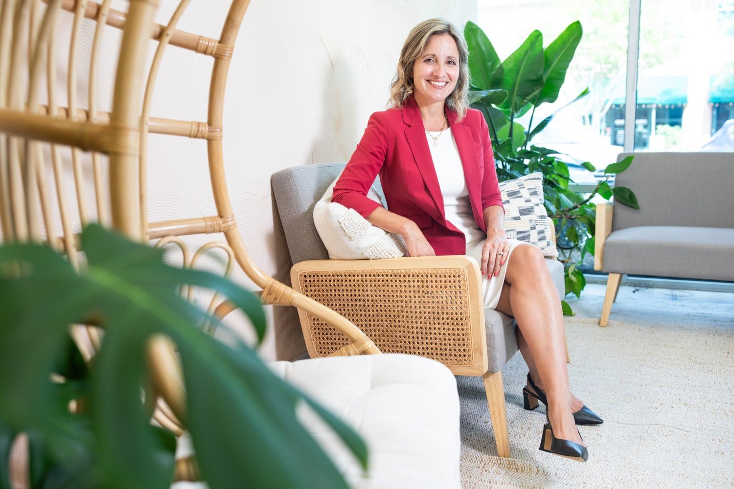 Jenn Meaney, Wilmington NC real estate broker, seated in a bright coastal living room