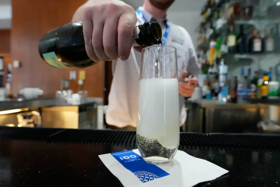 A bartender pours a glass of sparkling wine at the United Club lounge in Minneapolis. AP Photo/Chris Carlson