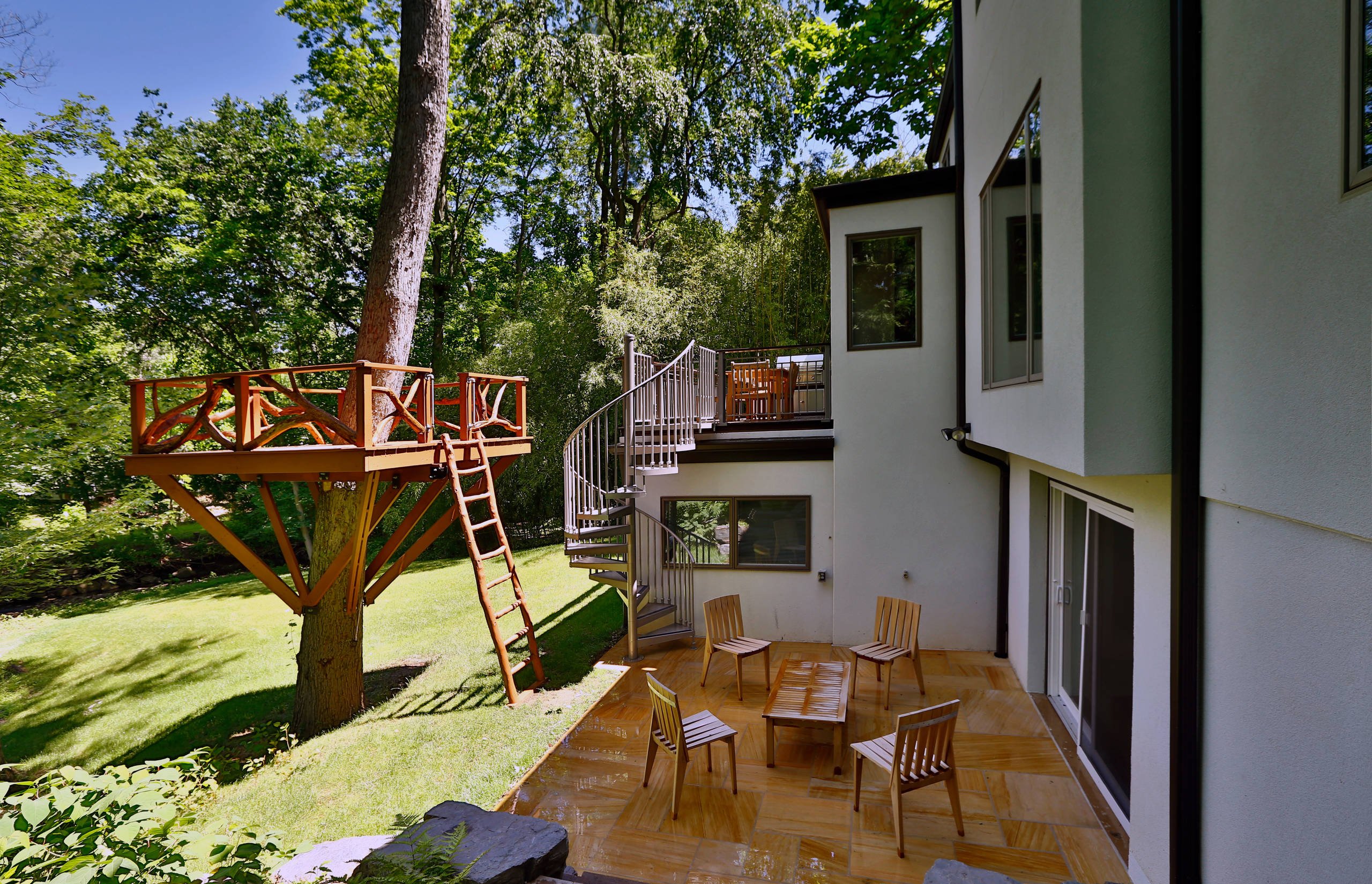 Wooden treehouse and rear exterior of home