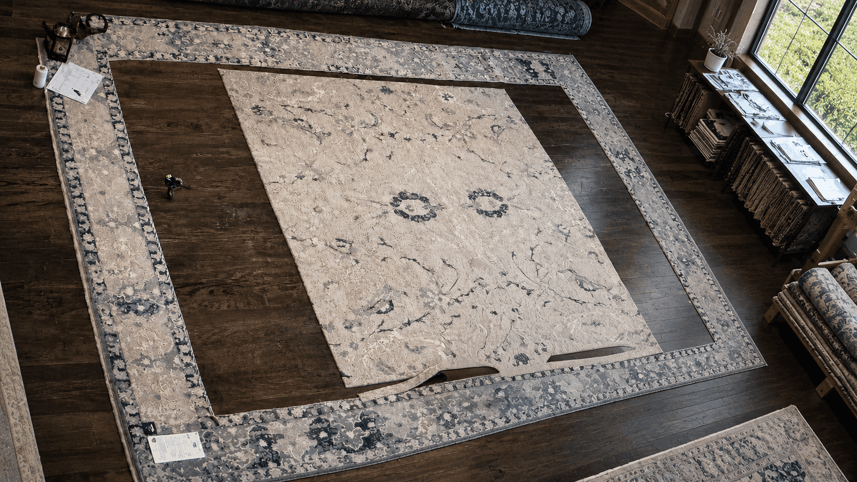 Artisan cutting an area rug to custom dimensions at the Rug Refinery workroom