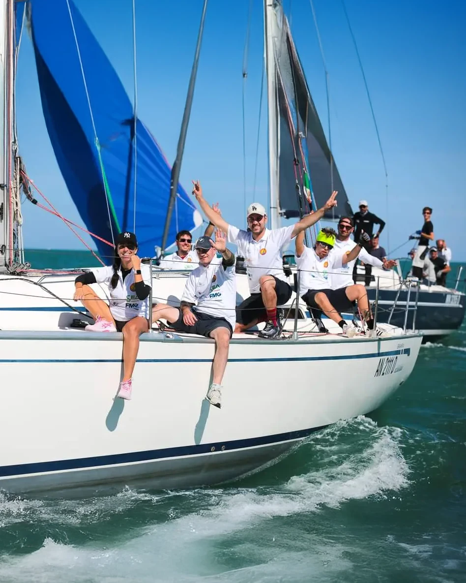 L'equipaggio di Una Vela per Tutti esulta a bordo durante una regata
