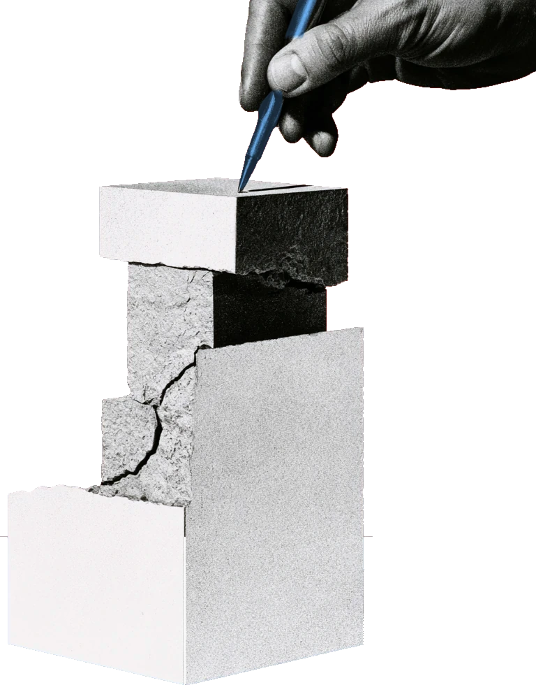 Una mano con una penna tocca la cima di una pila di blocchi attraversata da una crepa