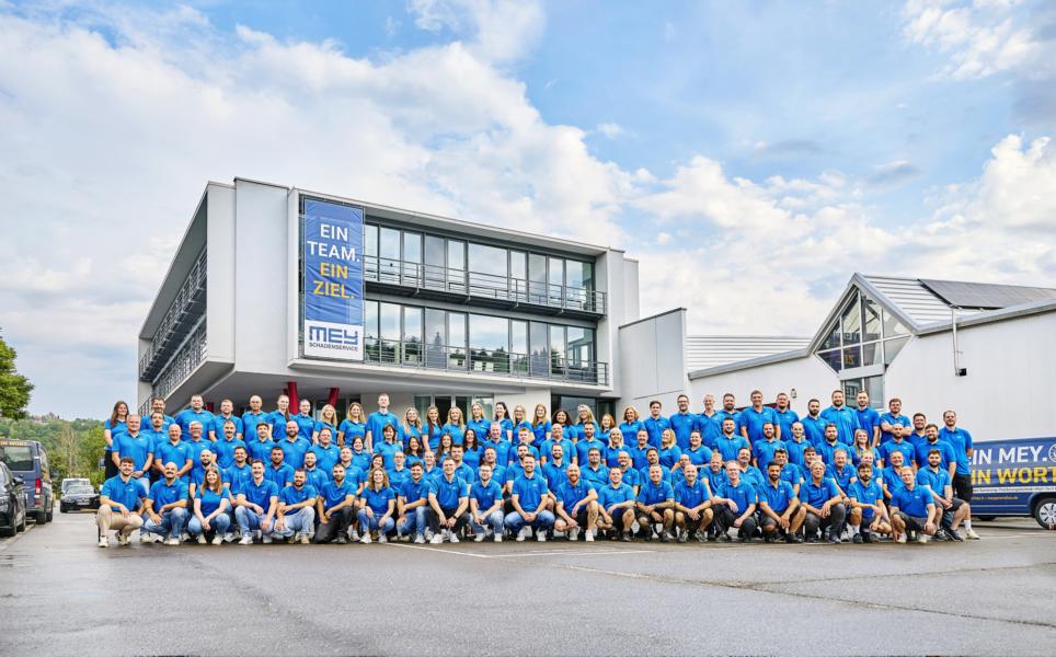 Gruppenfoto des Mey-Teams vor dem Firmengebäude