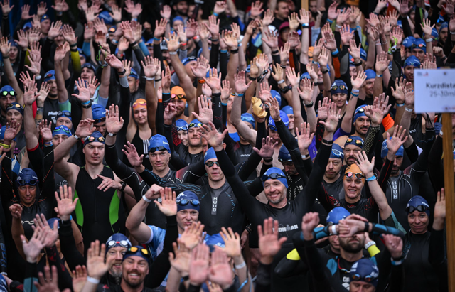 Triathletinnen und Triathleten im Neoprenanzug vor dem Schwimmstart