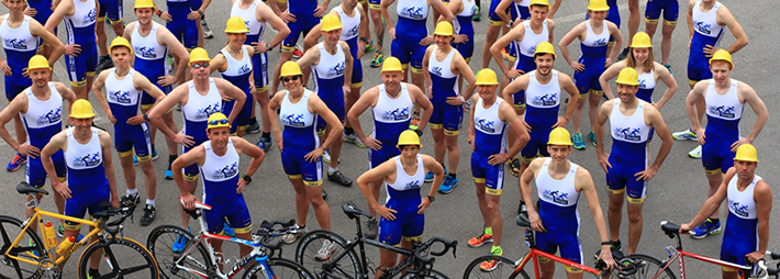 Triathlon-Team mit Helmen und Rädern vor dem Start