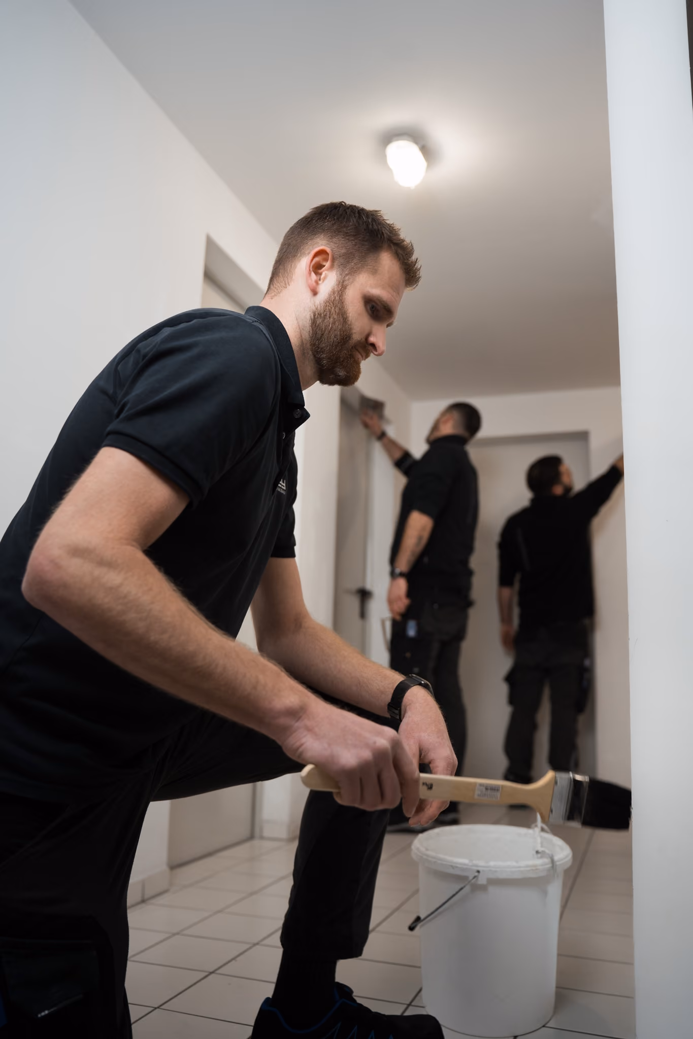 Handwerker bei Malerarbeiten im Treppenhaus