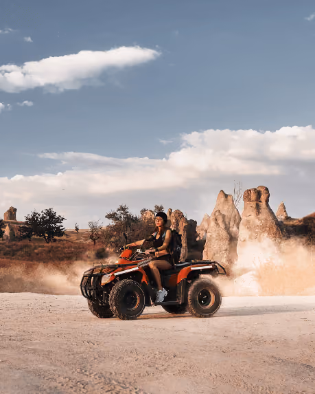 Woman riding a quad bike past the fairy chimneys of Cappadocia