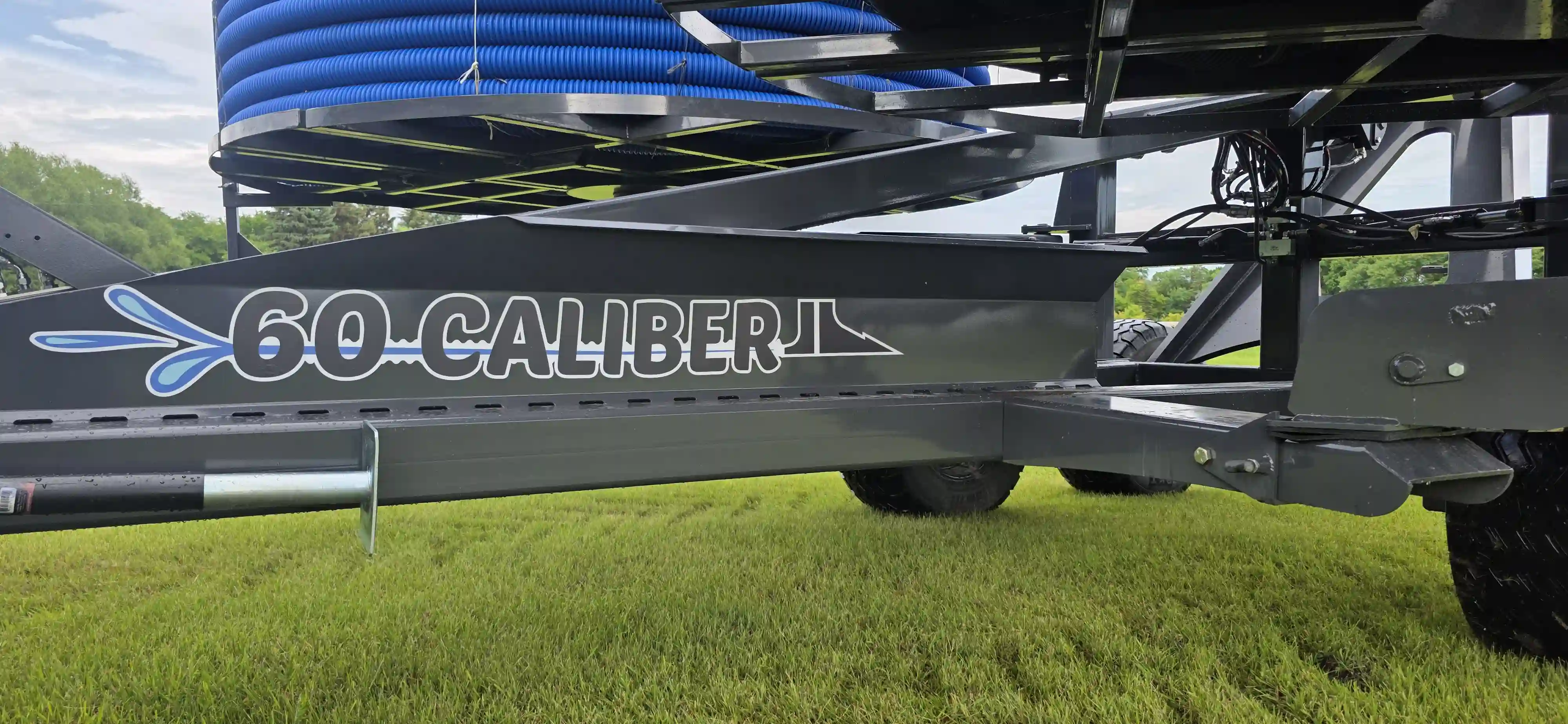 Close-up profile view of the new 60 Caliber tile plow logo printed cleanly on the side of the heavy-duty gray steel equipment frame.