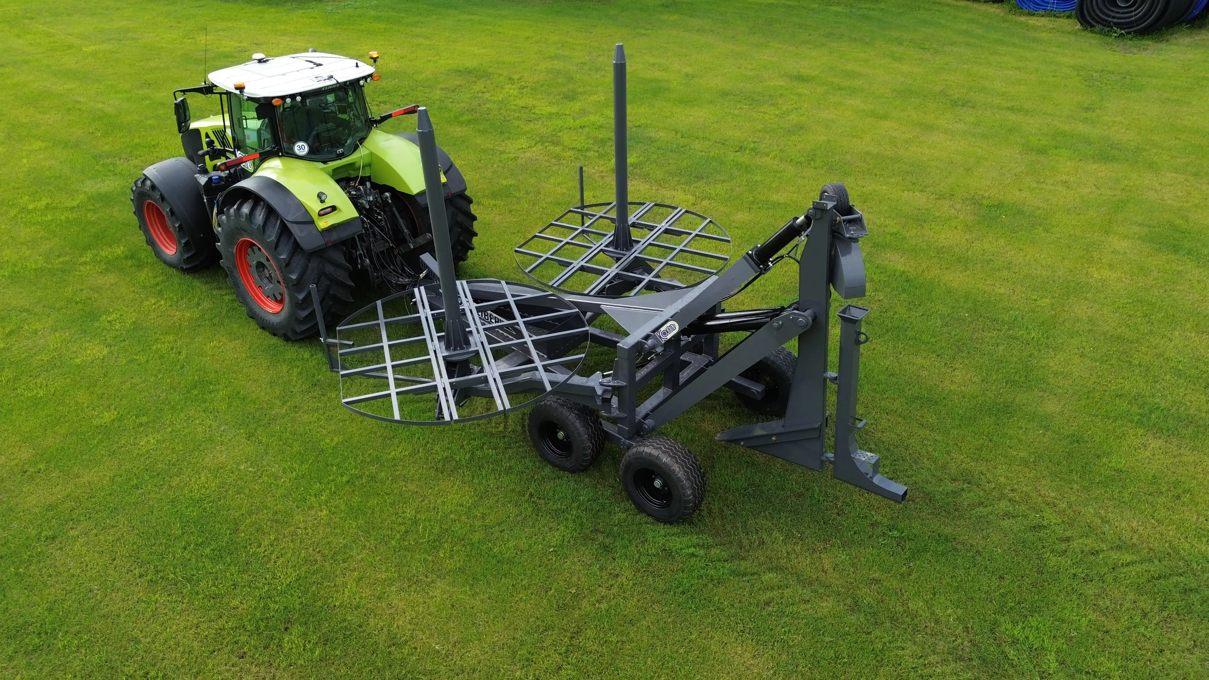 An overhead aerial view of an unloaded 60 Caliber tile plow, exposing the heavy-duty steel frame, vertical loading spindles, and foldable stringer tables.