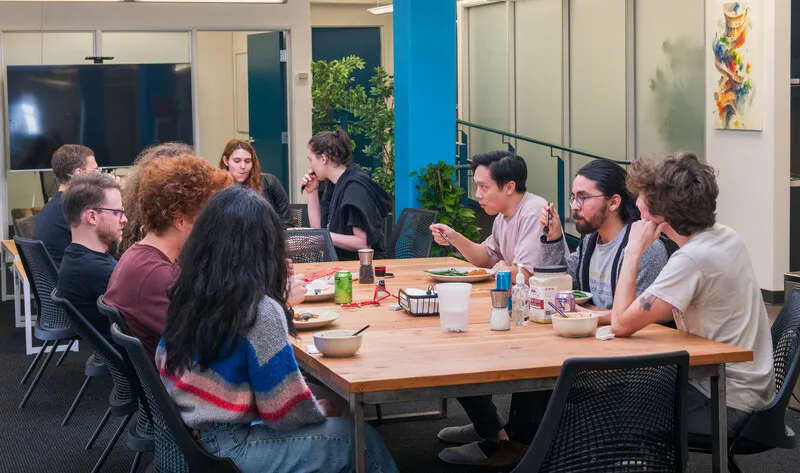 A group gathered round dining tables eating