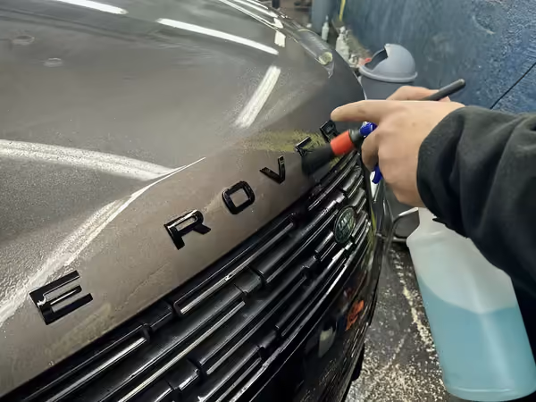 Nettoyage au pinceau du lettrage d'un Range Rover, finition detailing chez Bingo'z