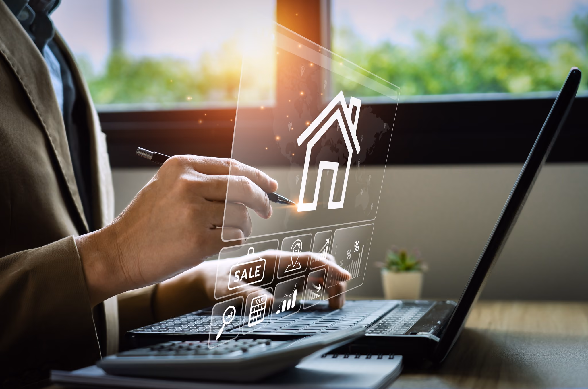 A hand using a laptop overlaid with property search icons including a house and a for-sale tag