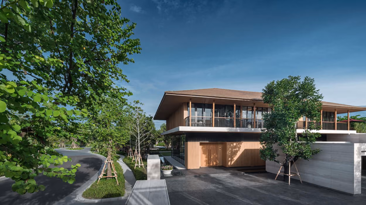 A render of a luxury Bangkok house with a broad timber roof, set among mature trees