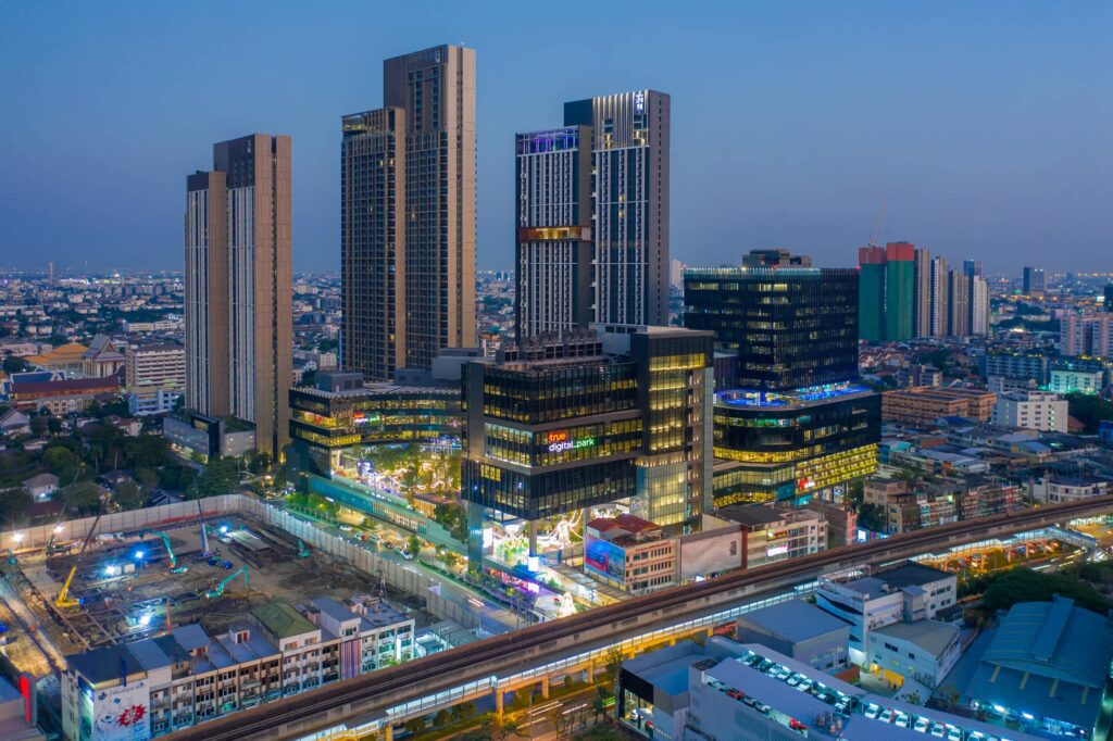 Whizdom Inspire Sukhumvit at dusk, with lit streets and the BTS line below