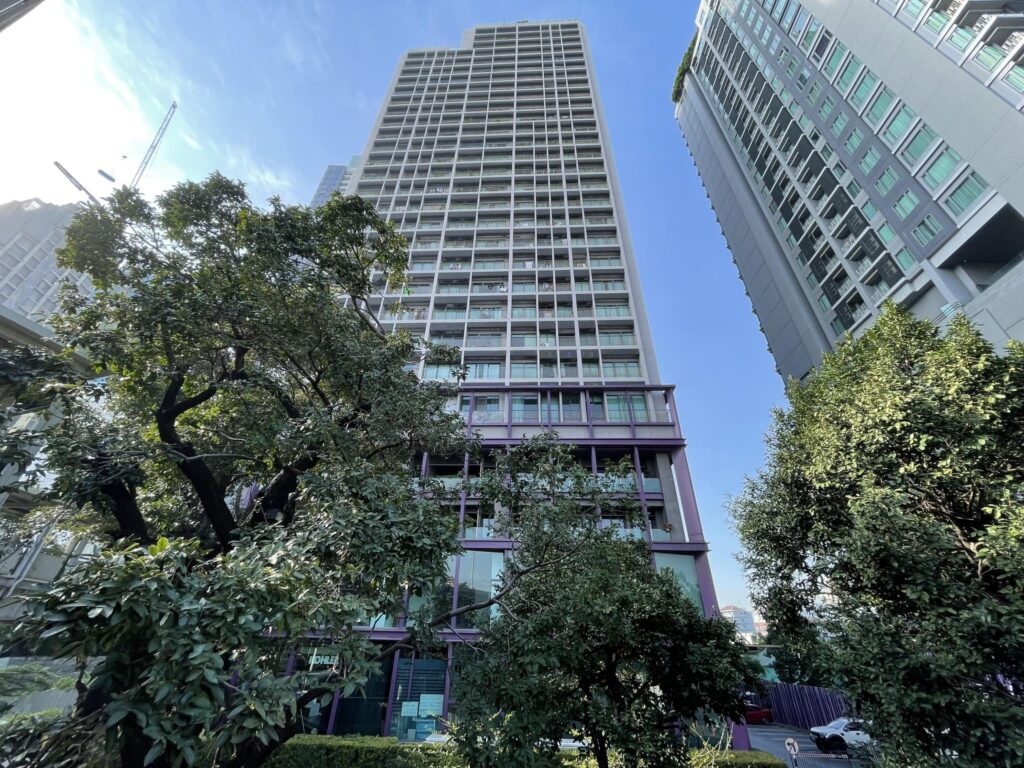 Looking up at the Noble Remix condominium tower in Thonglor, framed by trees